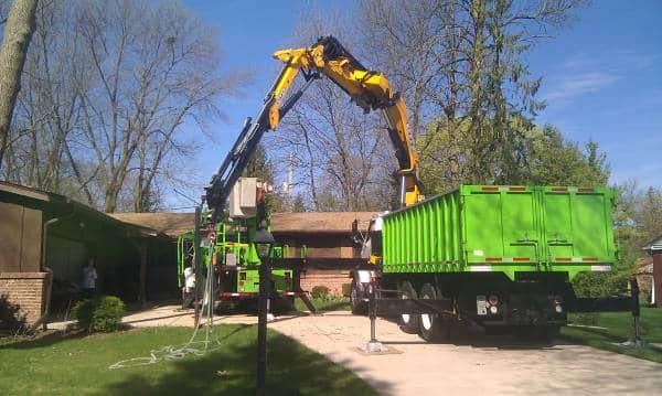 Knuckle boom vehicle loading tree debris