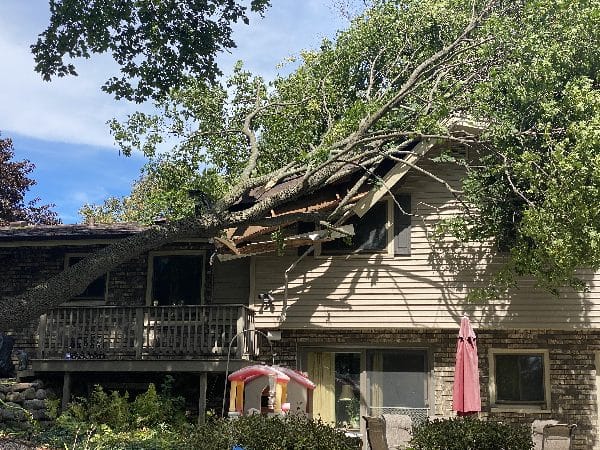 Storm damage clean-up after a tree falls onto a home.