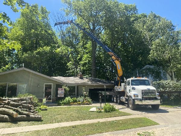 Knuckle boom vehicle in action at a cut-and-go operation at a home.